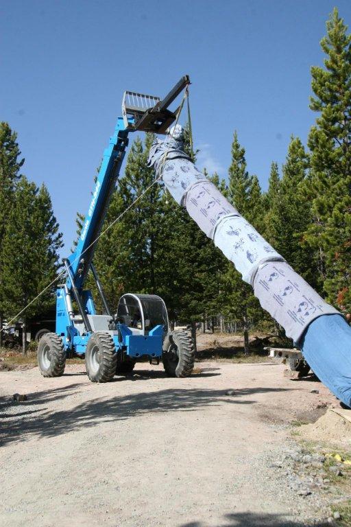 Totem pole being dragged into place by a machine