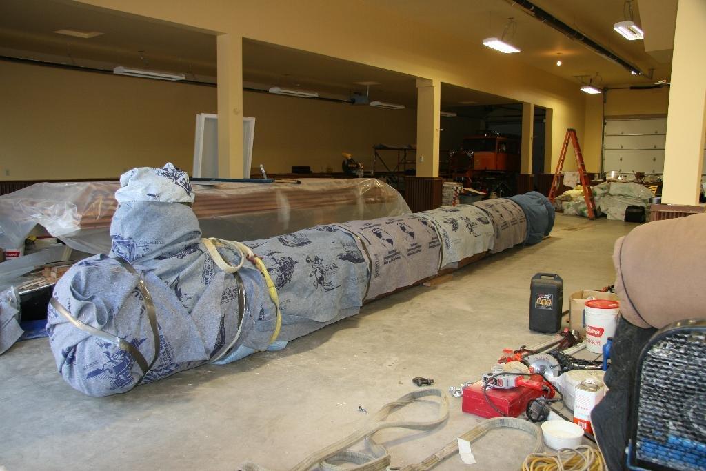 Totem pole in workshop after being assembled, all the segments covered in material