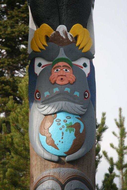 Totem pole segments under the top, including a human face, an aquatic creature, and something resembling a globe